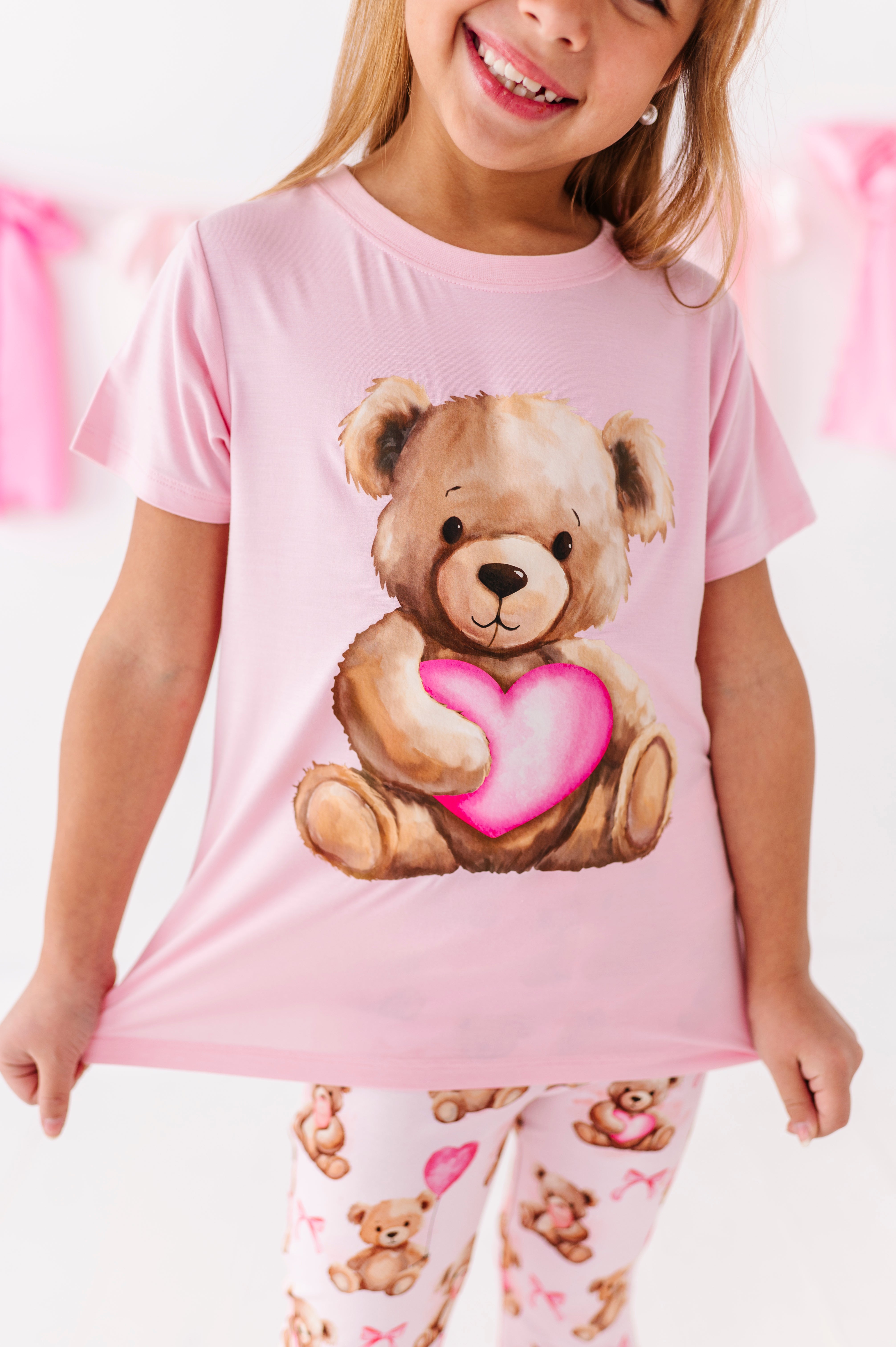 Close-up of pink bamboo t-shirt with watercolor teddy bear heart graphic